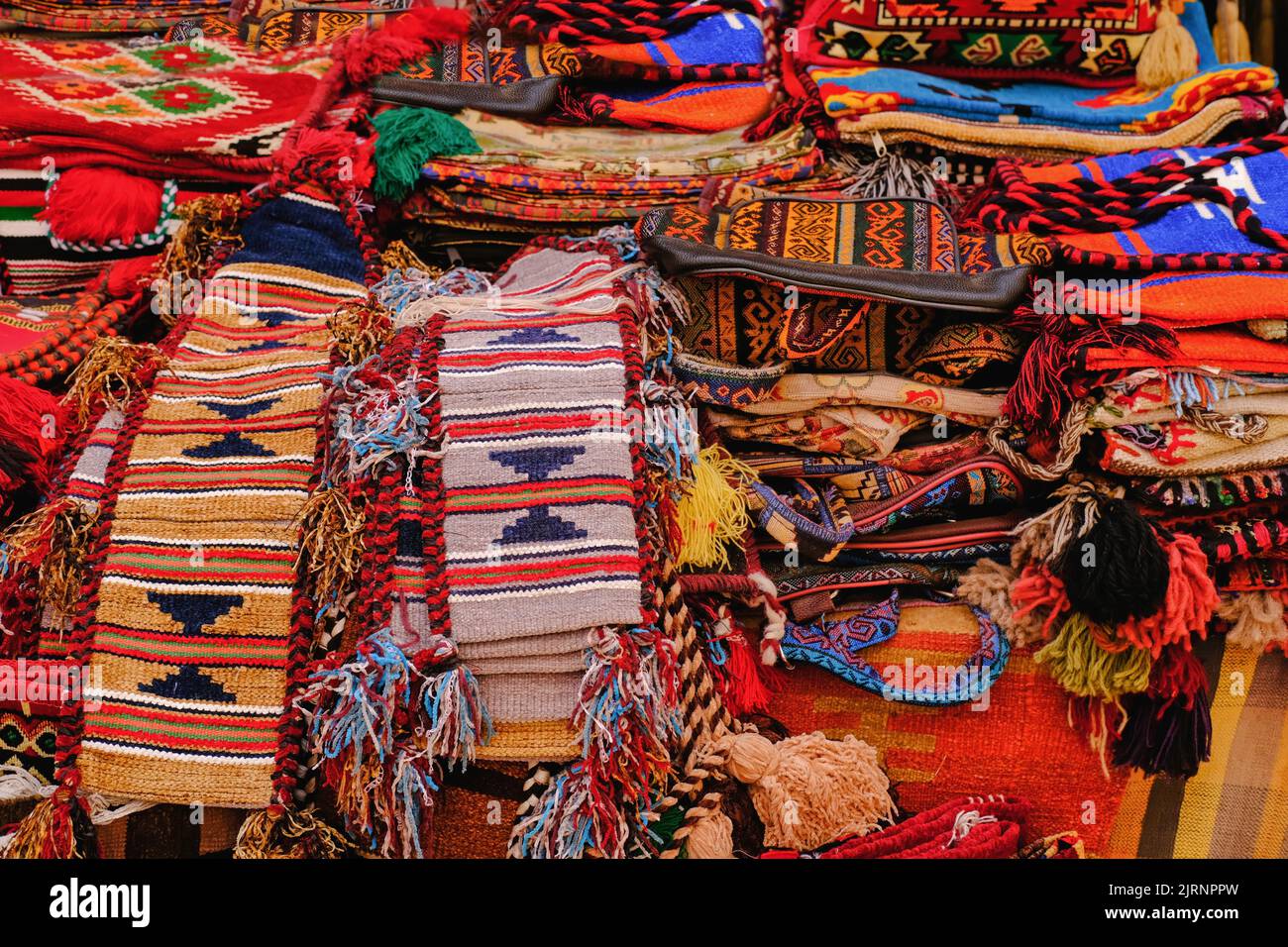 Mostra con assortimento di tappeti orientali di colore rosso brillante con motivi ornamentali tradizionali nel bazar medio orientale. Foto Stock