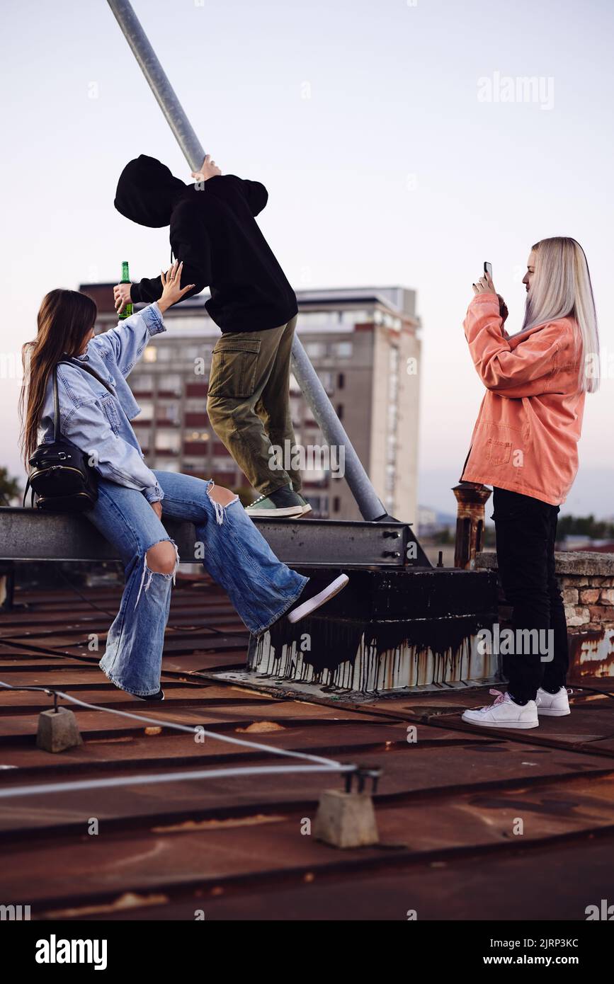 Adolescenti appesi sul tetto e bevendo birra. Foto Stock
