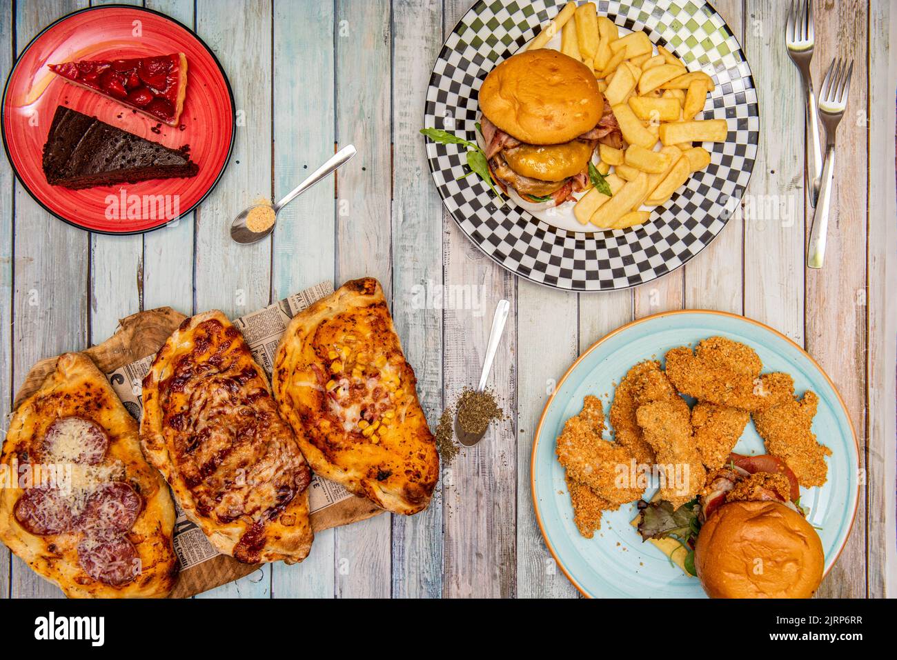 Un vassoio di ardesia nera con antipasti internazionali, crocchette spagnole, guacamole messicane con nachos, linghette di pollo della Louisiana e pane all'aglio italiano Foto Stock