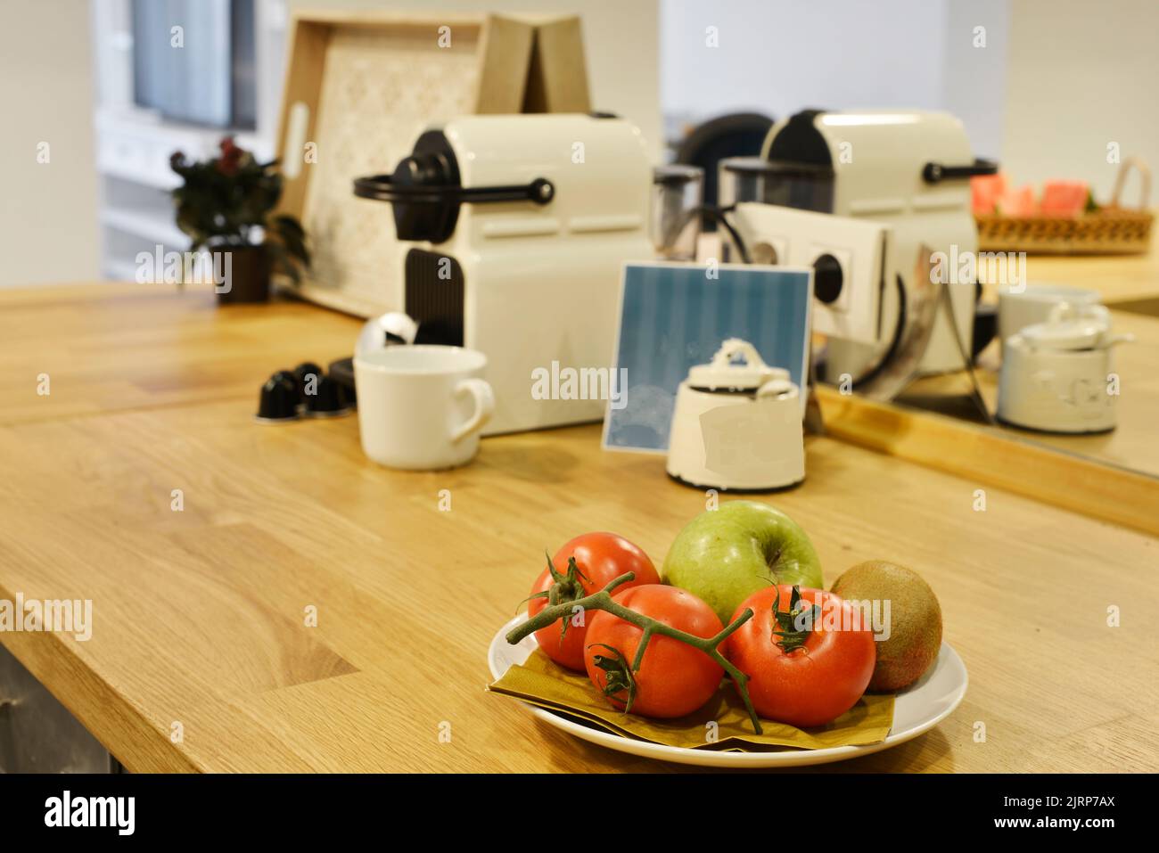 Sala da pranzo tavoli in legno con sedie abbinate e banconi con frutta e verdura Foto Stock