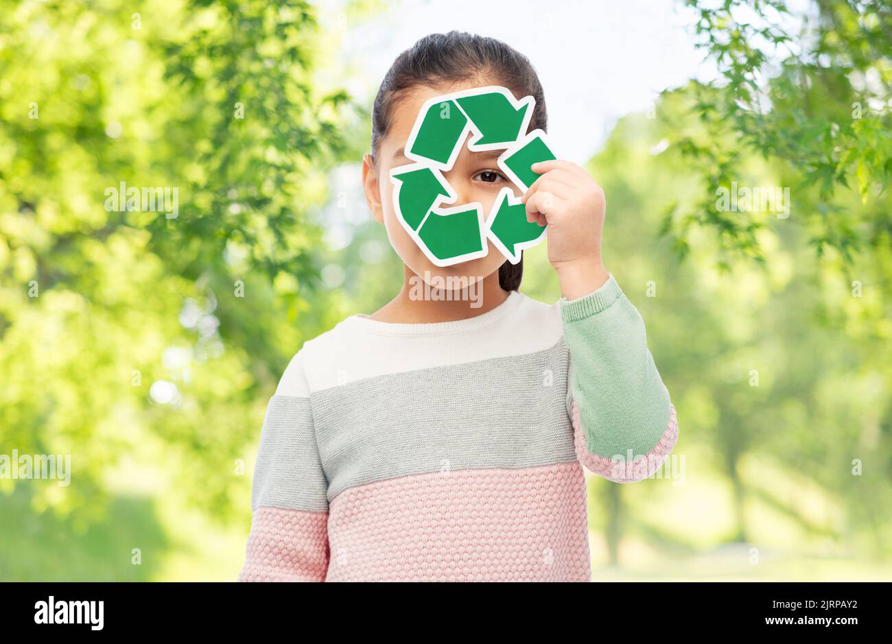 ragazza sorridente che tiene il segno verde di riciclaggio Foto Stock