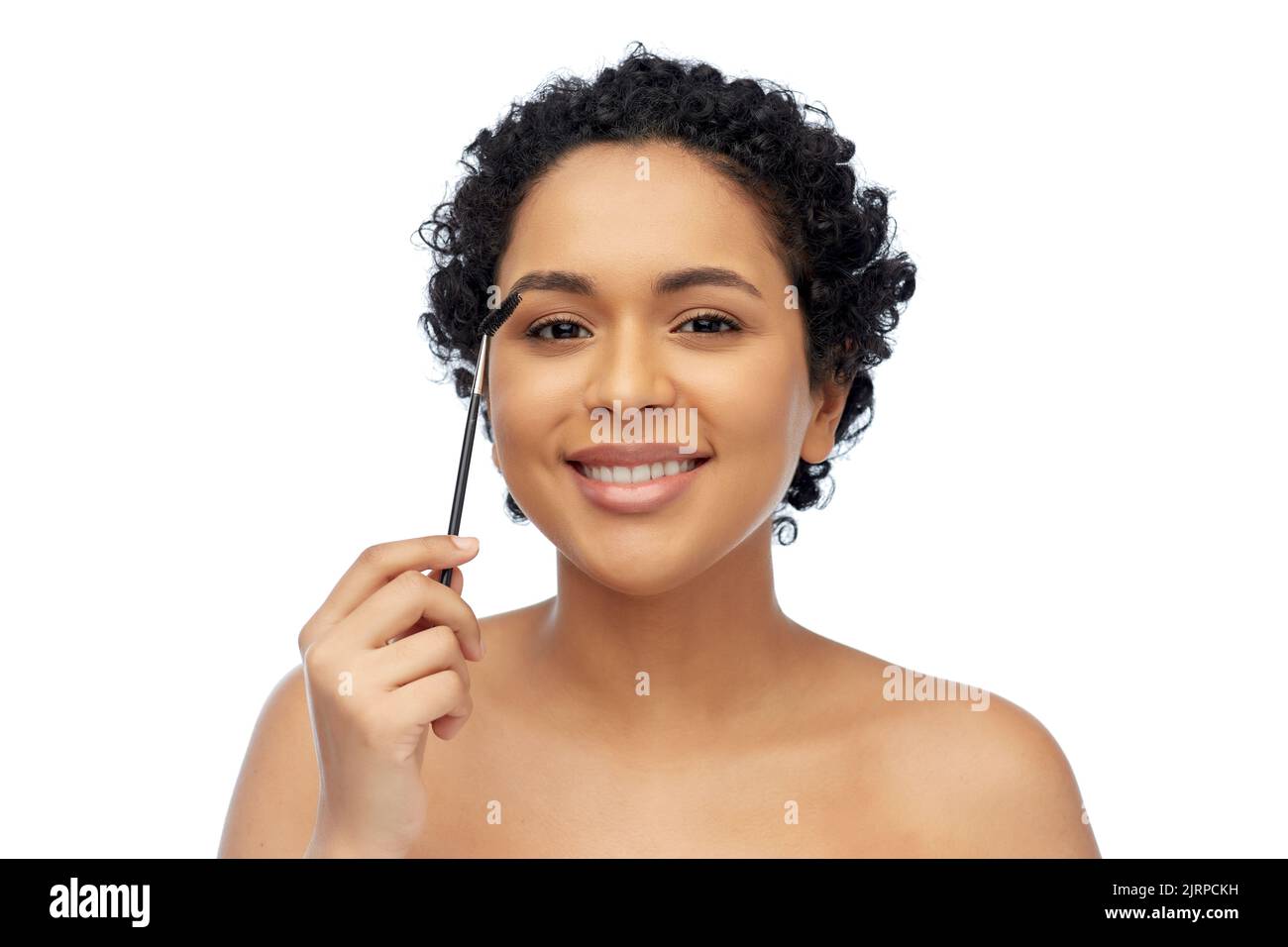 donna afroamericana sorridente con pennello mascara Foto Stock