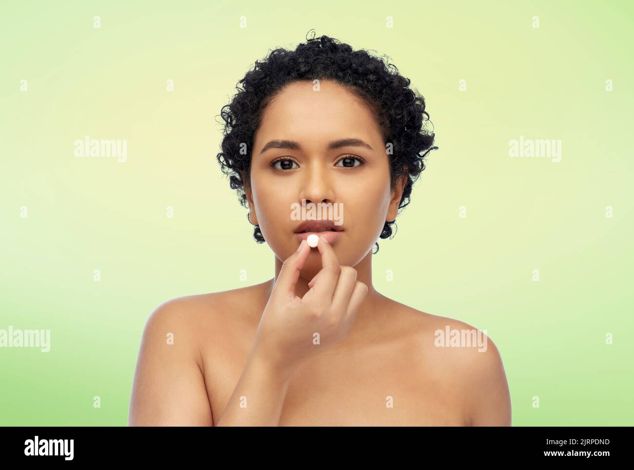 ritratto di donna afroamericana che prende la pillola Foto Stock