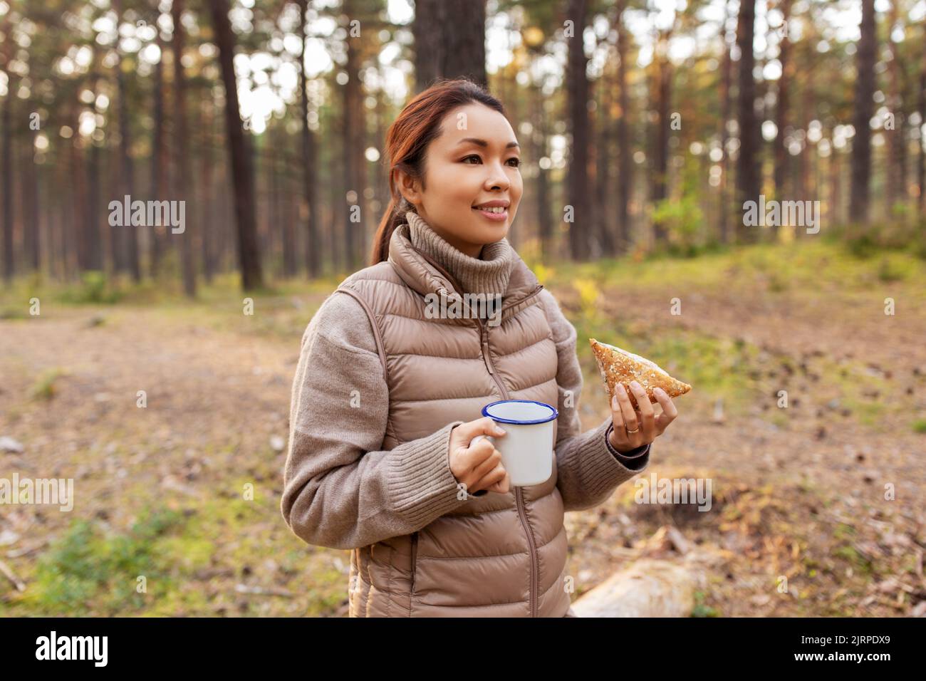 donna con funghi bevande tè e mangia nella foresta Foto Stock