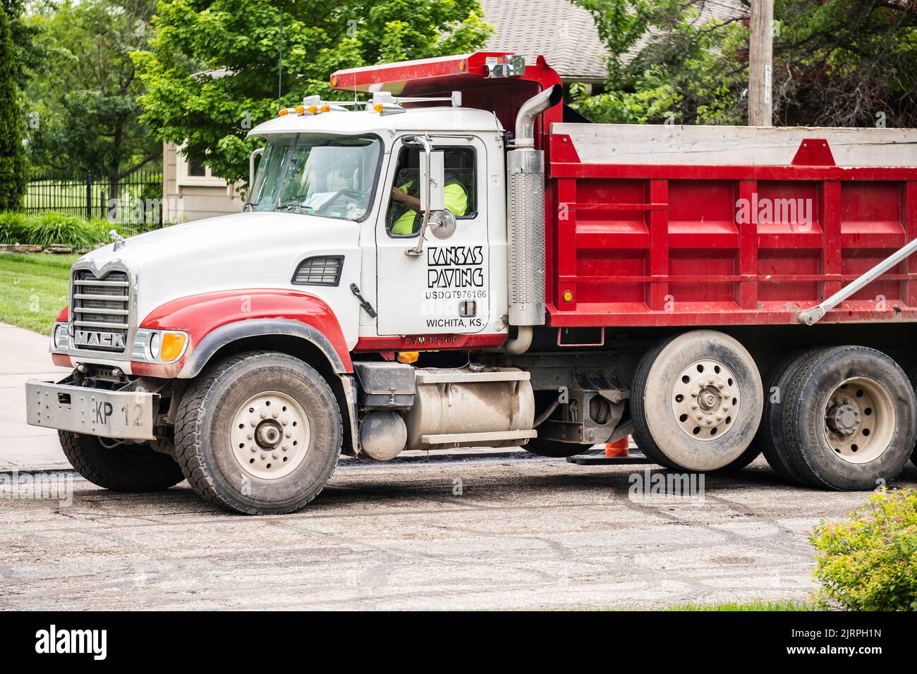 Un uomo gestisce un camion di pavimentazione di Mack Kansas per rifare una strada di quartiere di Wichita, Kansas. STATI UNITI. Foto Stock