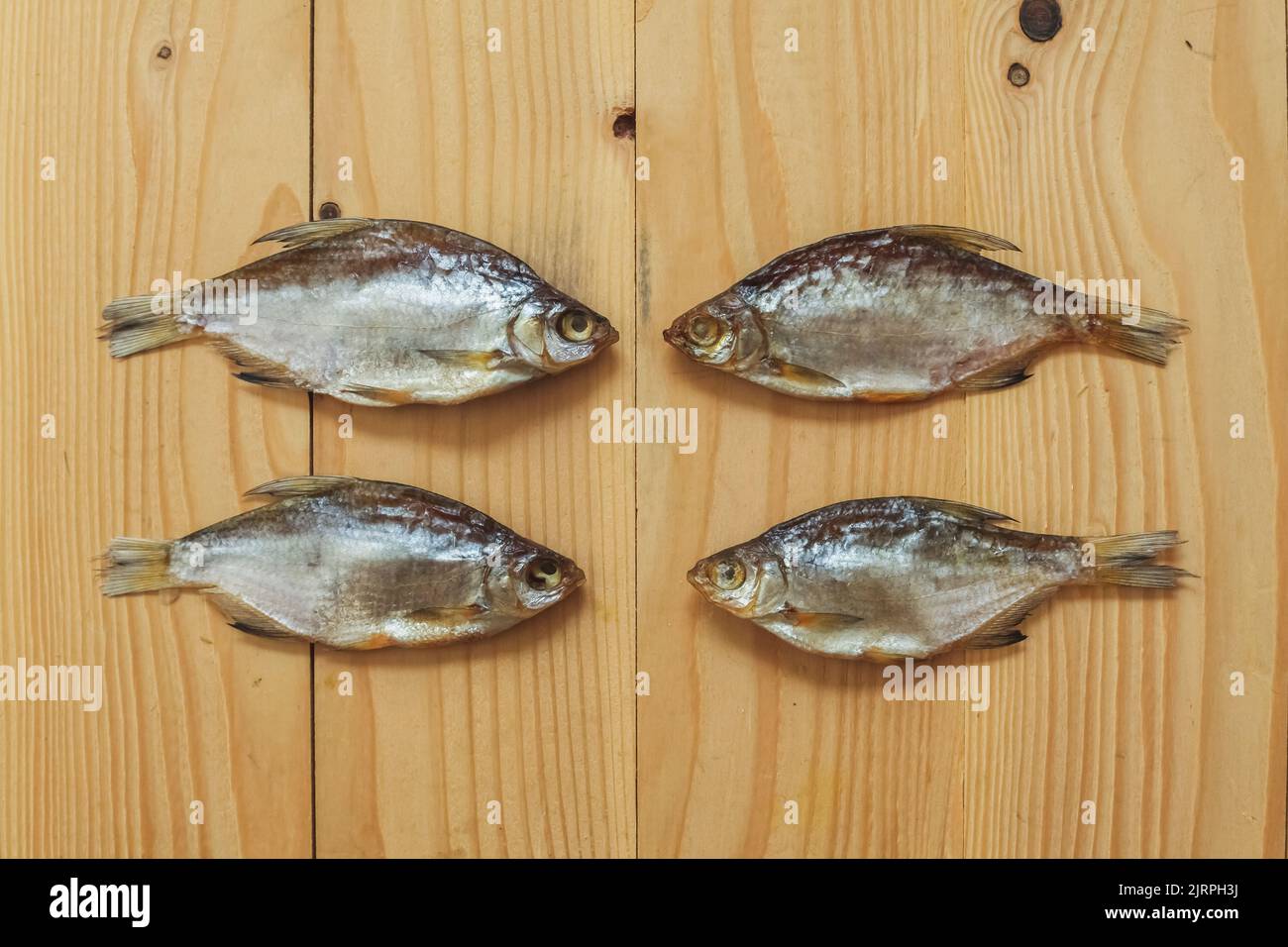 Pesce salato essiccato su uno sfondo di legno. Spuntini di pesce. Pesce secco per birra. Foto Stock