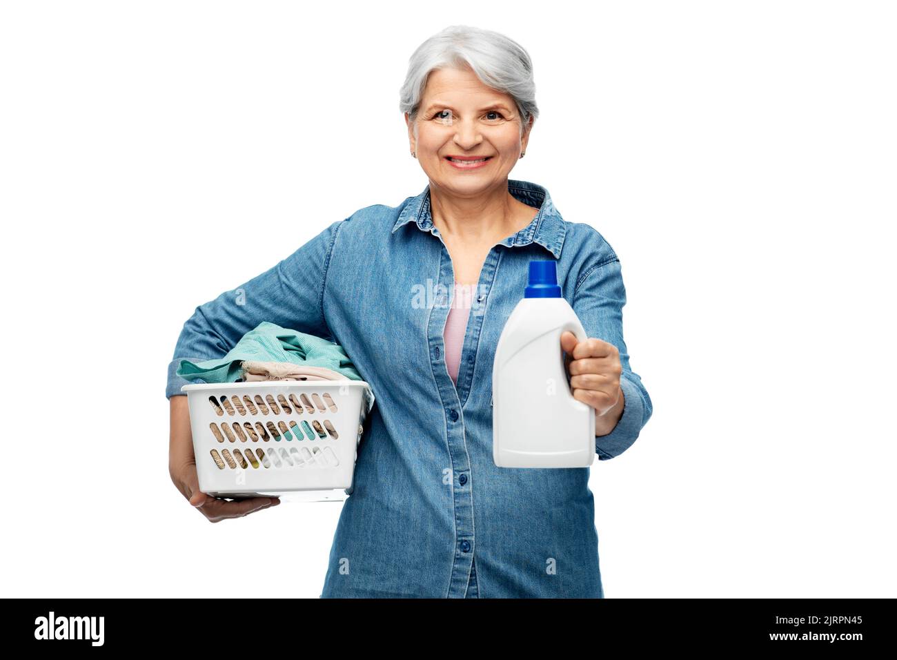 donna anziana sorridente con cesto per la lavanderia Foto Stock