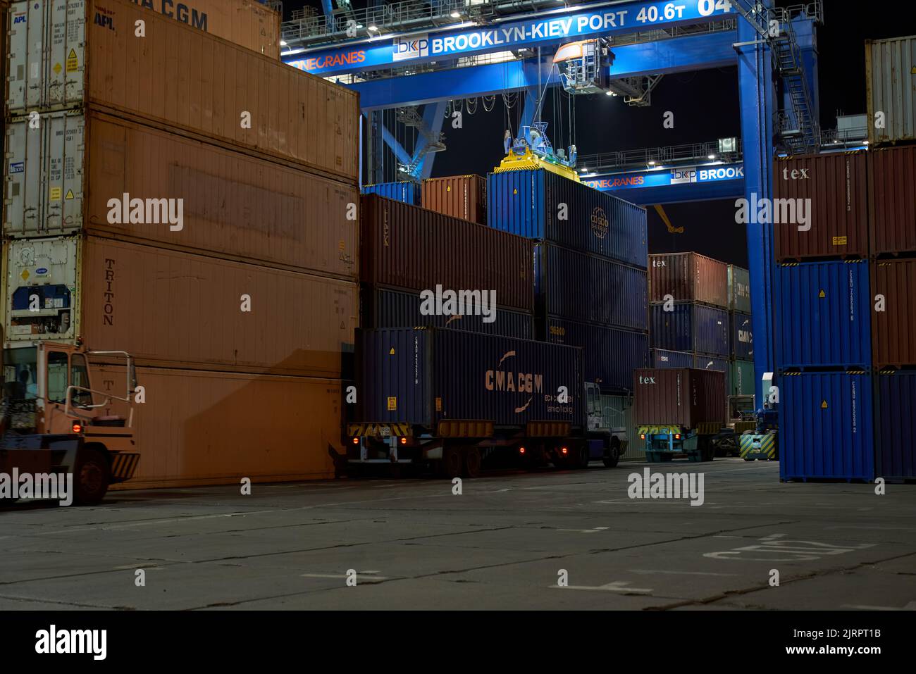 Funzionamento del terminal container di notte. Scarico della nave container di notte. Pile di contenitori al terminal Foto Stock