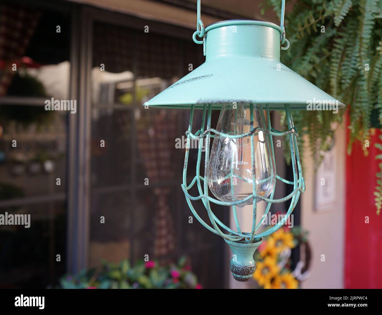 Un primo piano di una lanterna verde portico a energia solare luce con stile vintage gabbia verde Foto Stock