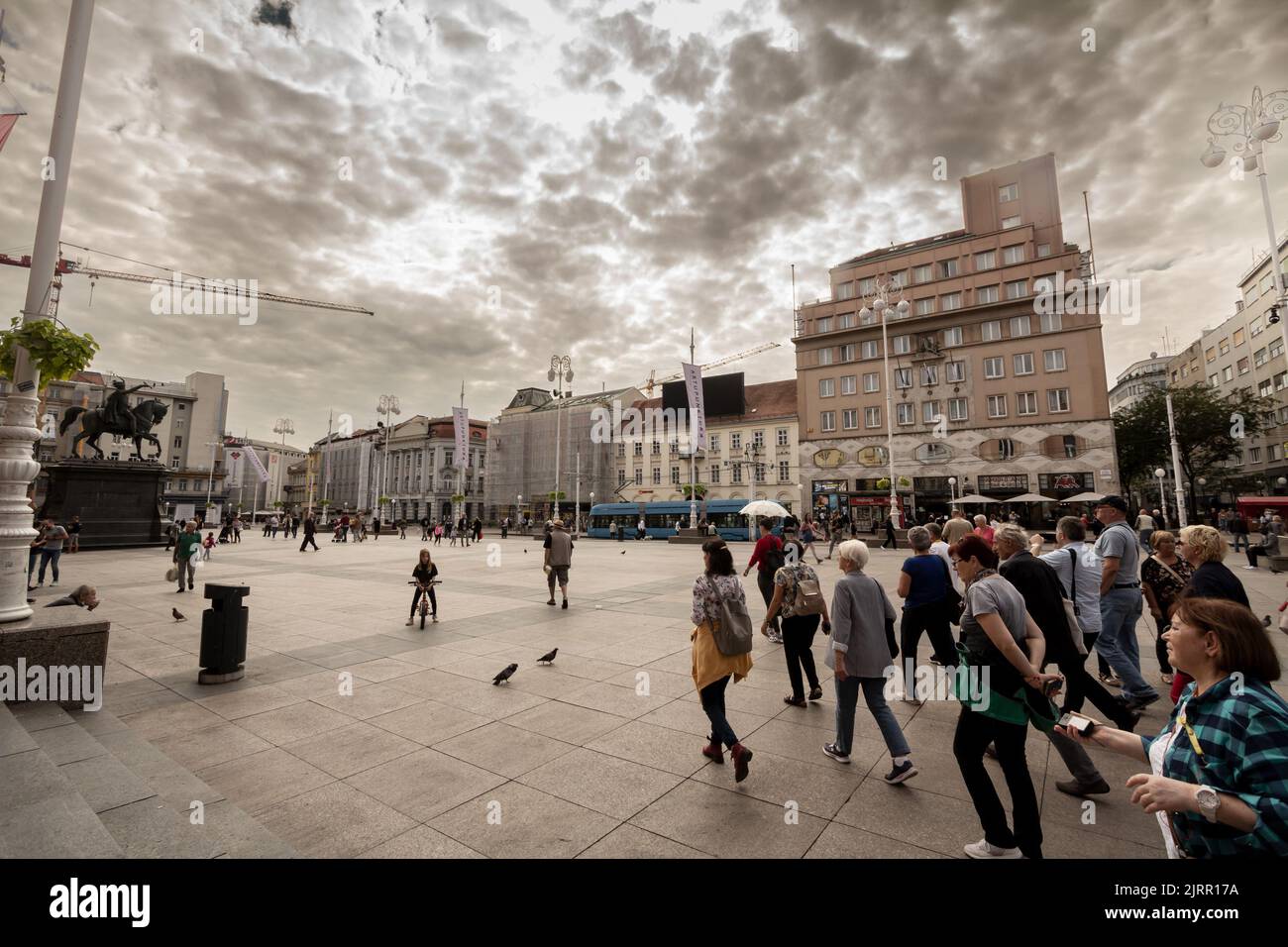 Foto del trg Bana Jelacica a Zagabria durante un pomeriggio nuvoloso con un gruppo di turisti in visita. Piazza Ban Jelacic è la piazza centrale del ci Foto Stock
