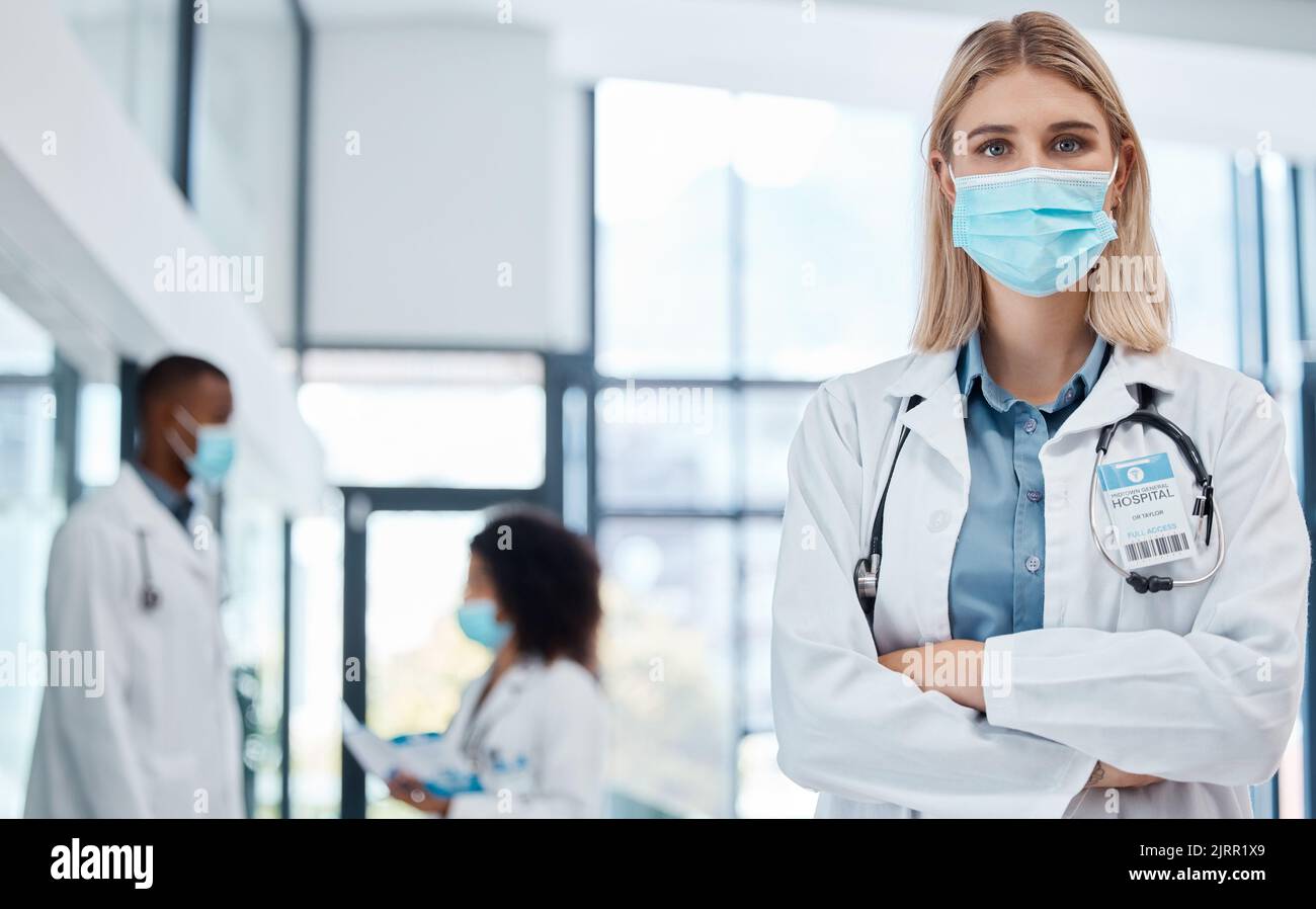 Medico, operatore sanitario e medico con maschera di cocid per proteggere dal rischio di virus lavorando in ospedale. Ritratto di un esperto, orgoglioso e. Foto Stock