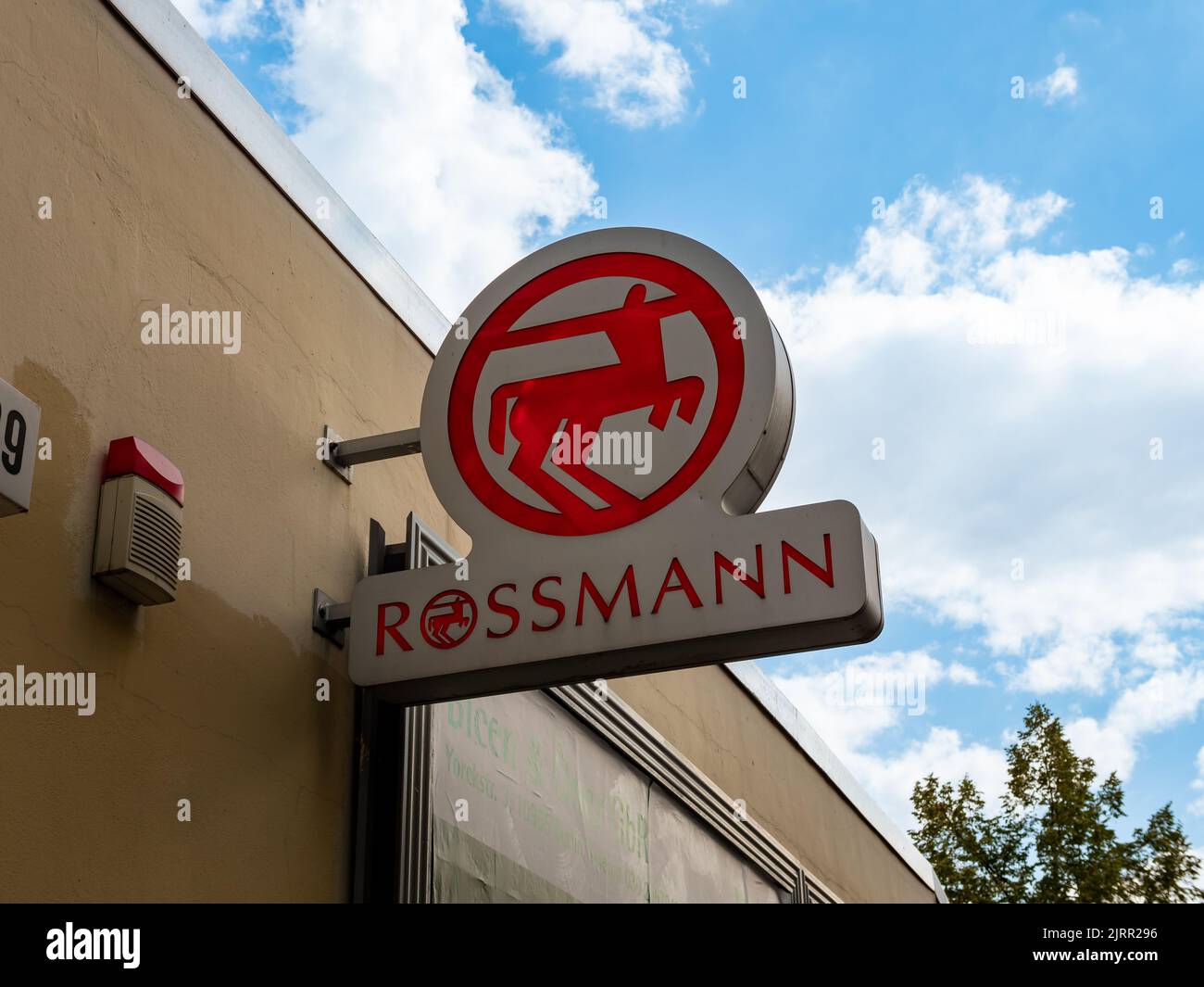 Logo Rossmann della catena di negozi di droga su un edificio esterno. Pubblicità del commercio tedesco su una facciata. Simbolo rosso centauro e scritta Foto Stock