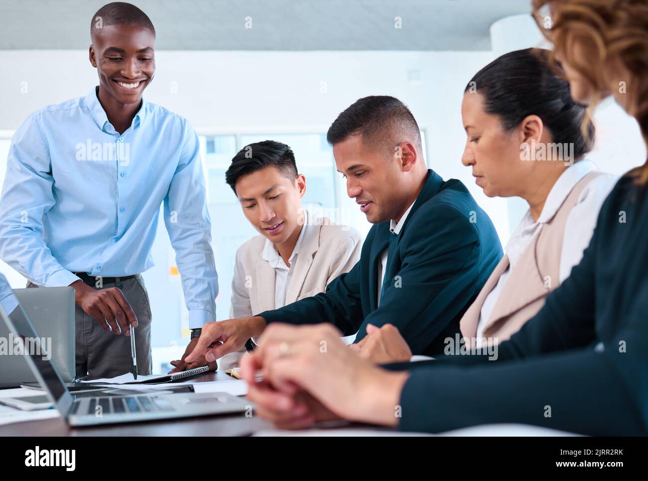 Gli uomini d'affari felici lanciano il Web site del ecommerce sul laptop con il team dell'ux o dell'interfaccia utente, il progettista grafico ed il responsabile di vendita. Lavoratori della diversità nelle imprese Foto Stock