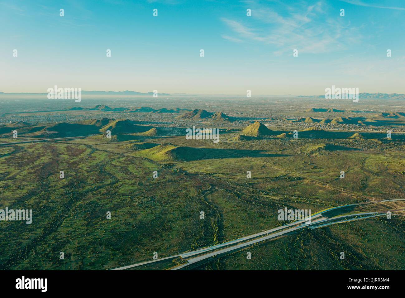 Le montagne si presentano come un paesaggio desertico, attraversato da strade, alla luce della mattina presto Foto Stock