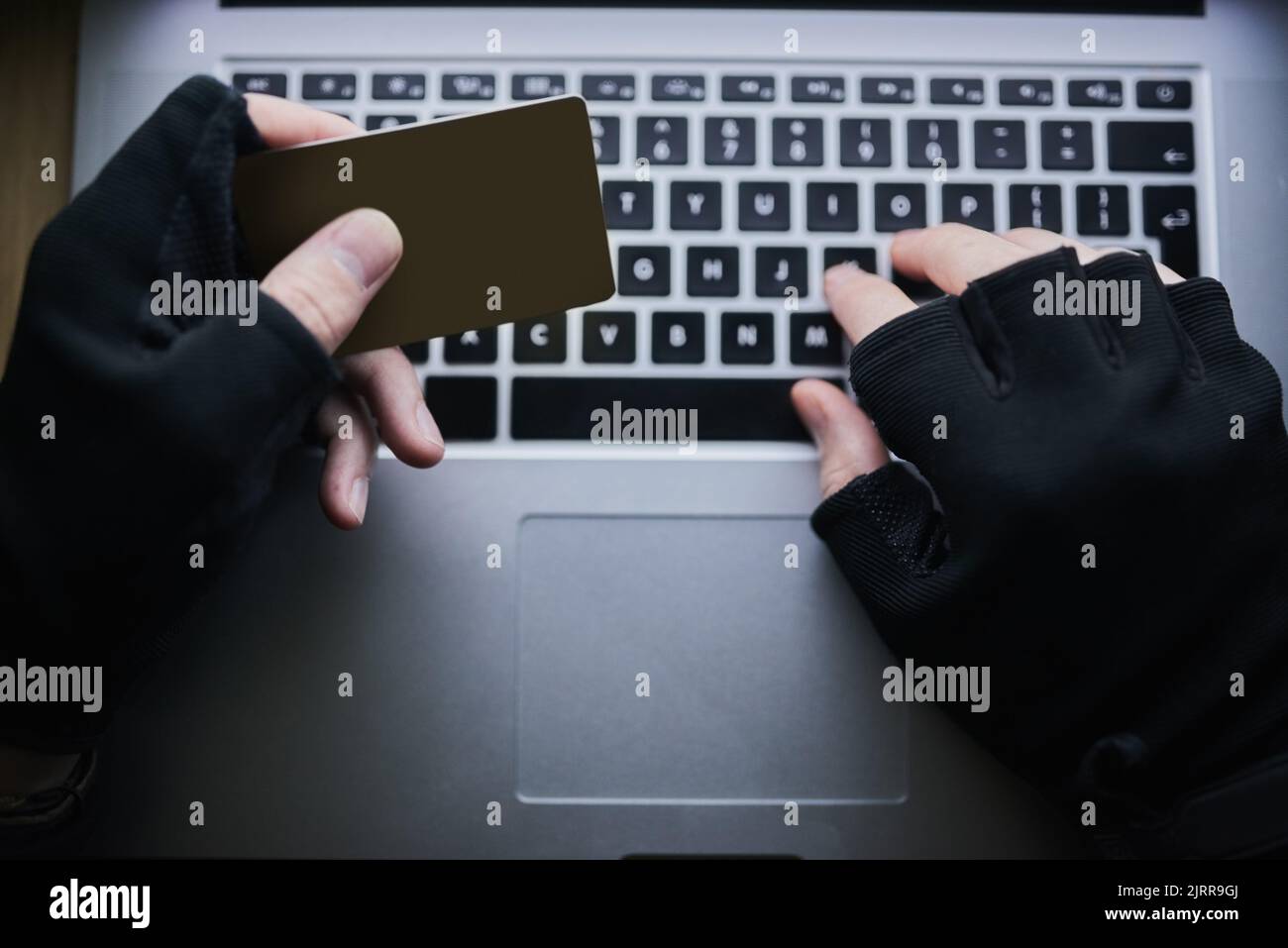 I vostri dati finanziari sono protetti. Un criminale non identificabile che utilizza un computer portatile per effettuare hack in un conto di credito. Foto Stock