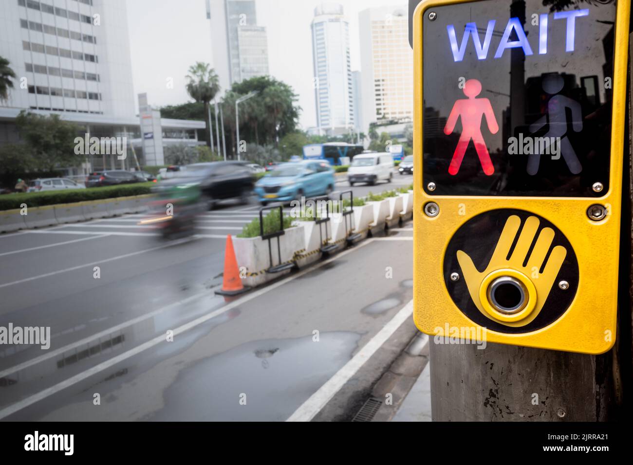 Il segnale di attesa si trova nell'area pedonale di attraversamento pedonale su una strada trafficata della città Foto Stock