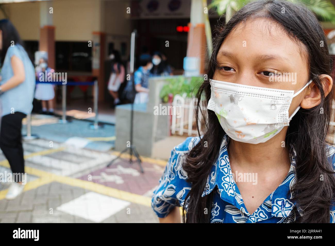 Studentessa del sud-est asiatico con maschera facciale di nuovo a scuola dopo una pandemia covida Foto Stock