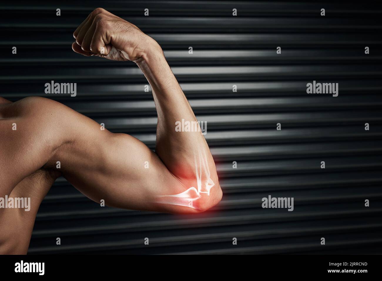 Spingendo il suo corpo al limite. Studio shot di un giovane muscoloso che flette il suo bicep con cgi evidenziando il gomito. Foto Stock