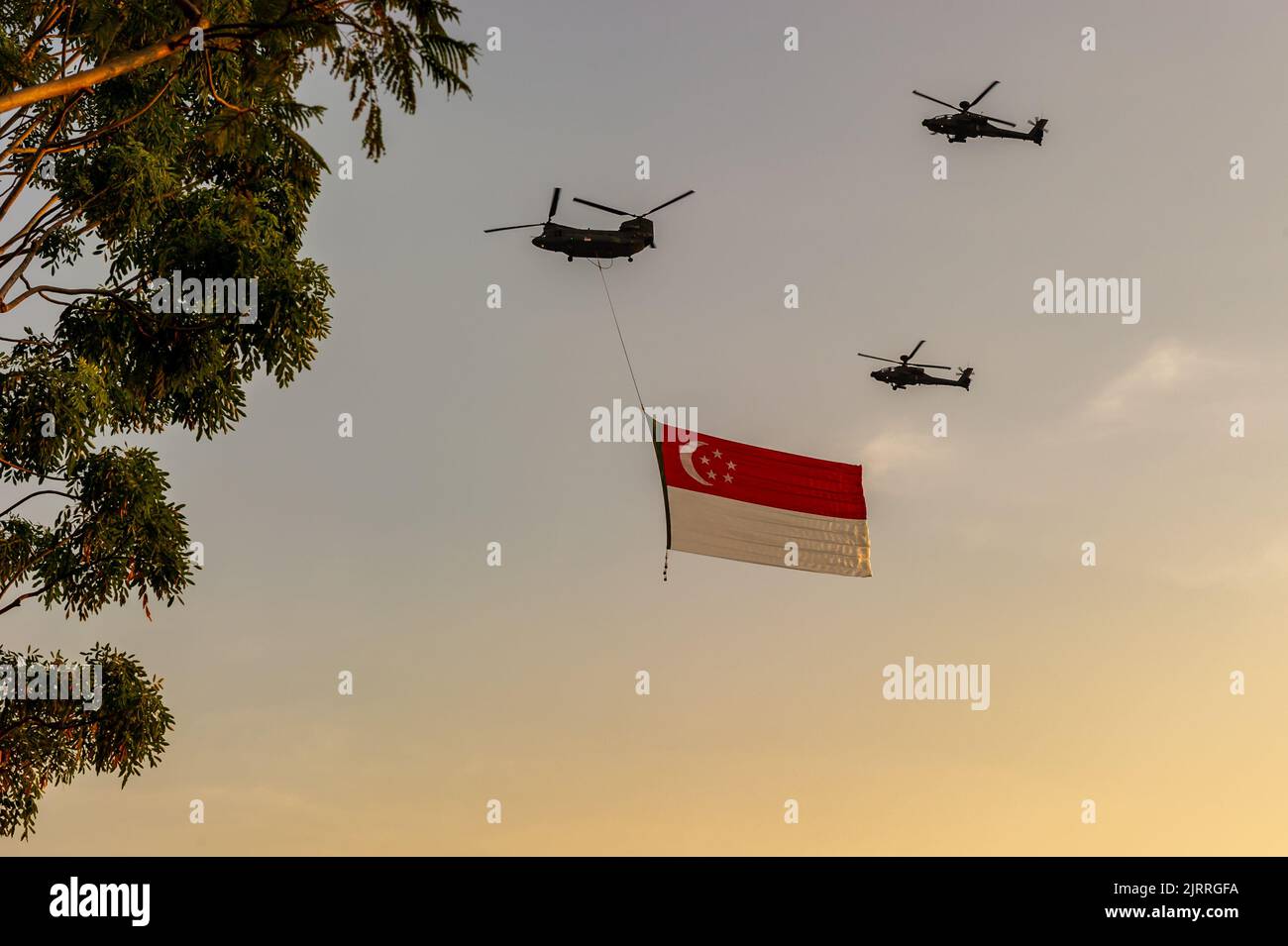 Singapore Flag è volato da un elicottero Chinook, accompagnato da due elicotteri Apache nel National Day 2022 di Singapore Foto Stock