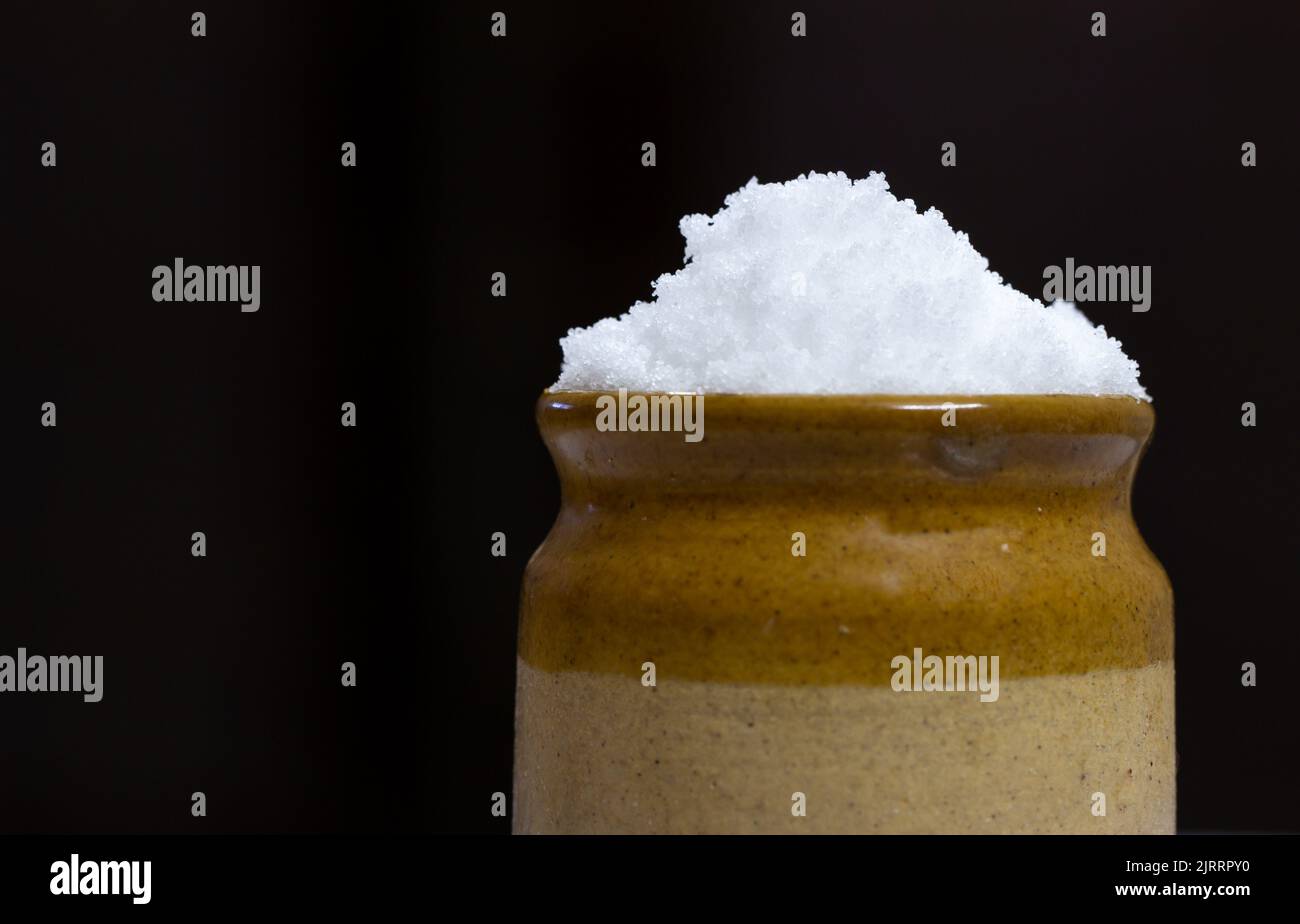 Sale marino granulato in un vaso di terra. Sale comune immagazzinato in vaso usato per cucinare Foto Stock