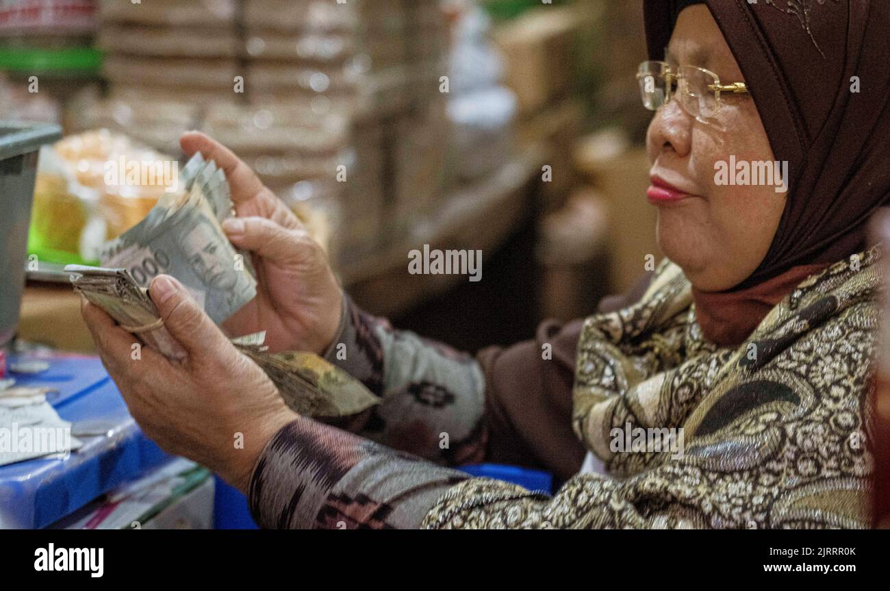 Indonesia, 13 2022 giugno - la donna conta la valuta indonesiana su un mercato. Foto Stock