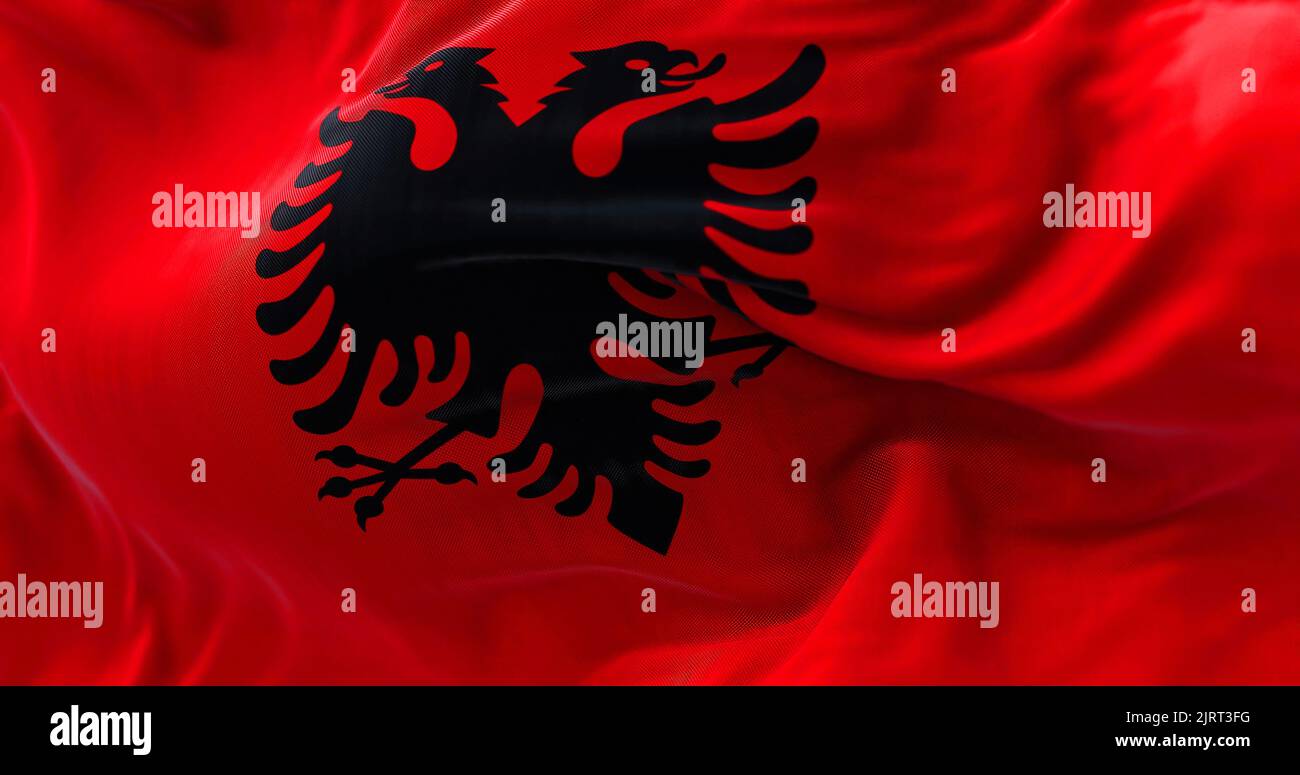 Vista ravvicinata della bandiera nazionale albanese che sventola nel vento. L'Albania è un paese dell'Europa sudorientale. Tessuto testurizzato sfondo. Selettivo foc Foto Stock