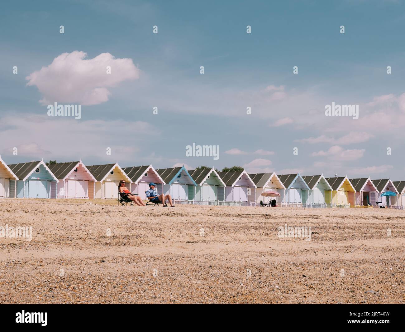 Estate pastello mare capanne e blu cielo spiaggia paesaggio in West Mersea, Mersea Island, Essex, Inghilterra UK - cielo blu estate sfondo vacanza Foto Stock