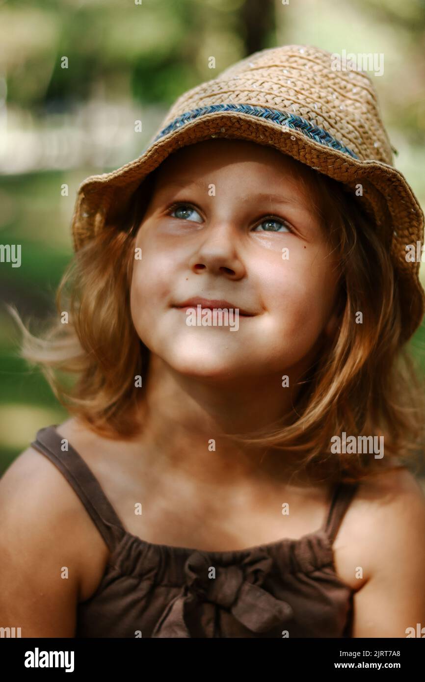 Carino biondo bambino 5 anni. Bambino in un cappello di paglia. Ritratto di una bambina primo piano. Per cercare. Foto Stock