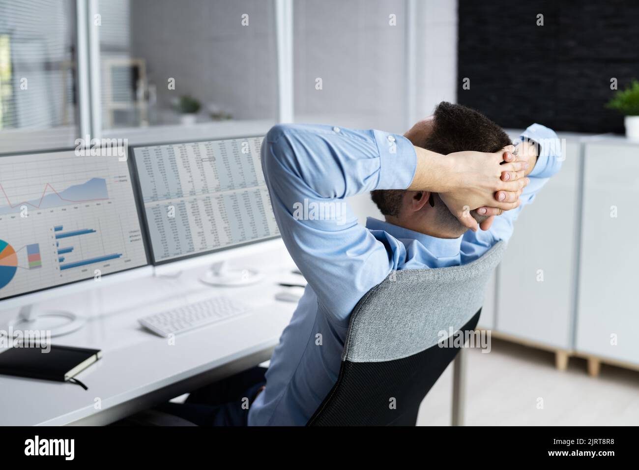 Consulente uomo rilassante in sedia da ufficio alla scrivania Foto Stock