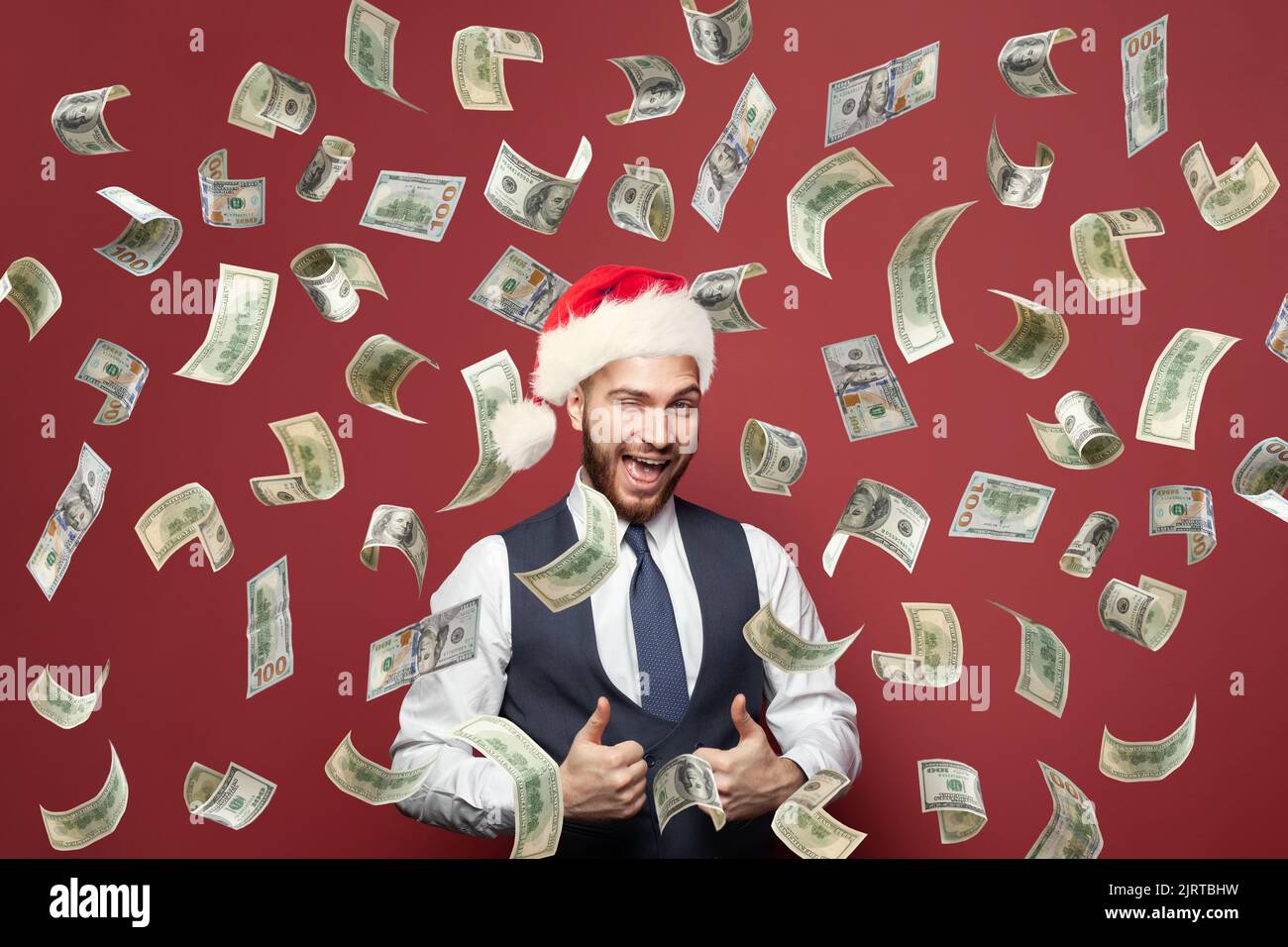 Ritratto di Natale di uomo d'affari a Santa cappello è felice di soldi pioggia. Enorme bonus di pagamento o concetto di vincita Foto Stock