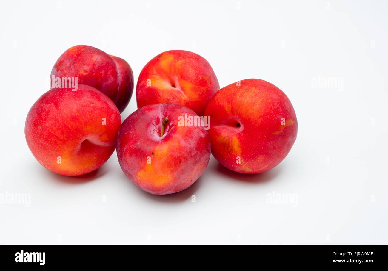 Prugne di frutta fresca isolate su fondo bianco Foto Stock