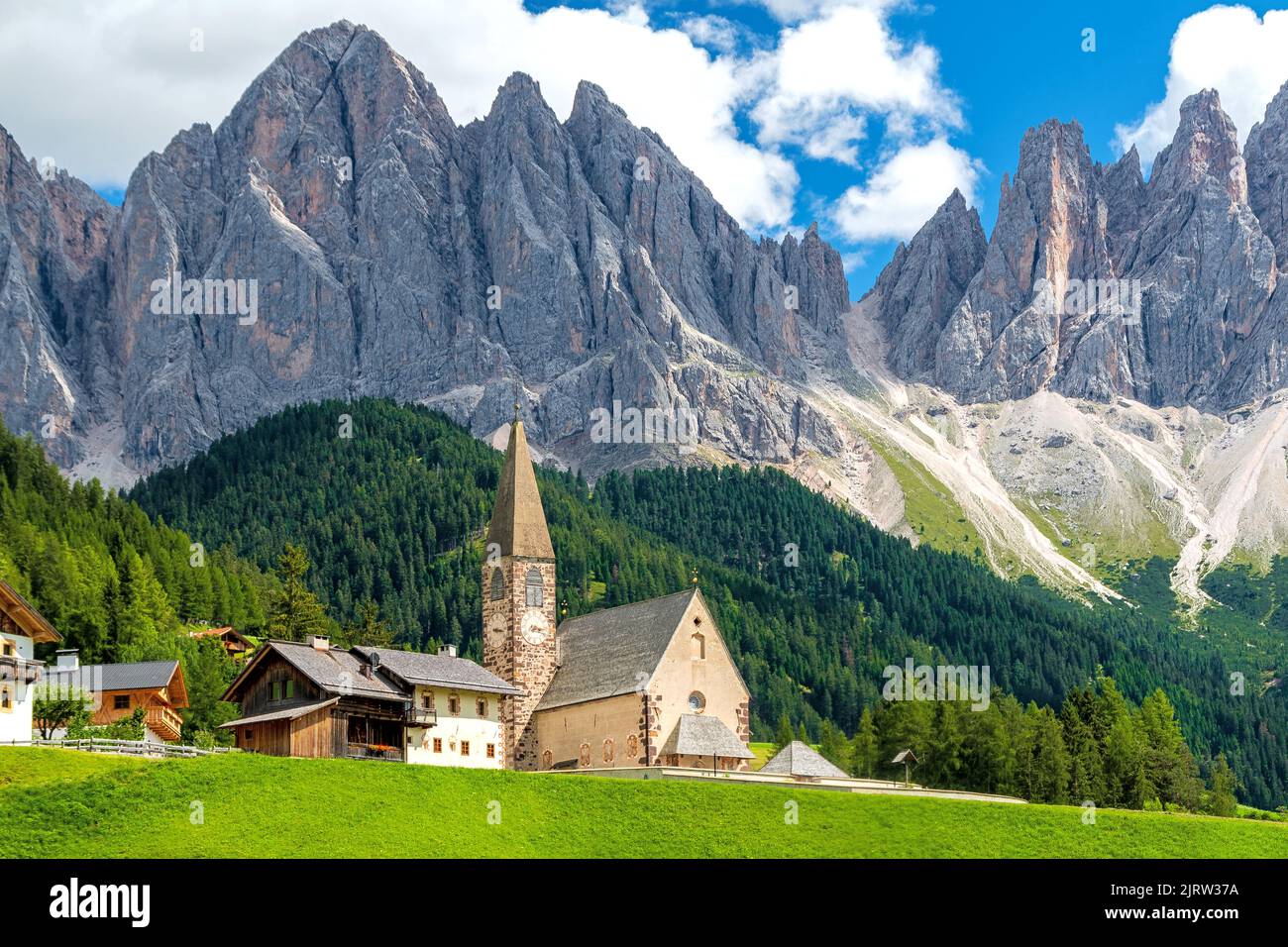 Piccola chiesa di Santa Maddalena a Villnöß (Funes) in Alto Adige nel nord Italia con il Gruppo delle Odle in fondo alle Dolomiti Foto Stock