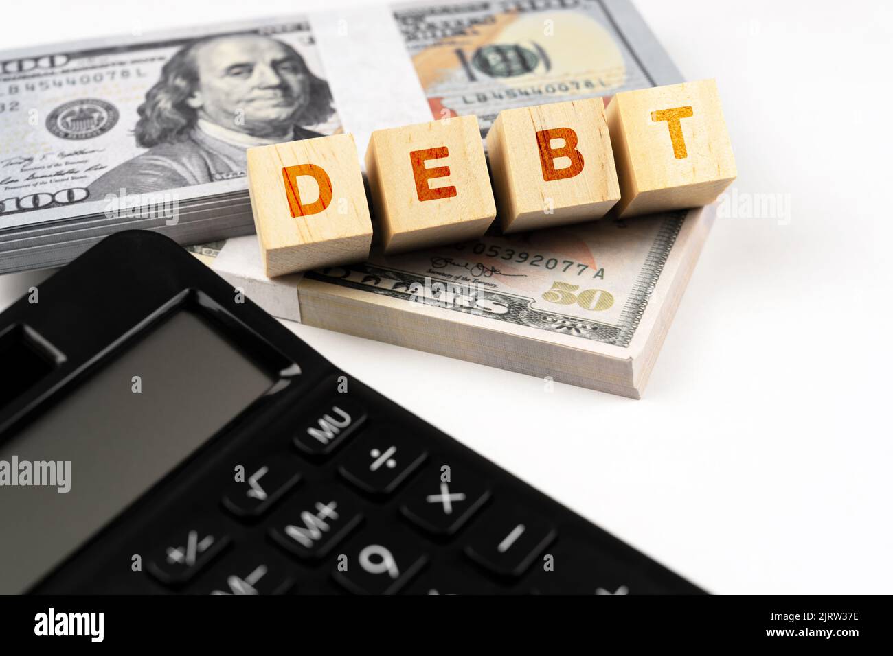 Testo del debito su blocco di legno con calcolatrice e carta di credito Foto Stock