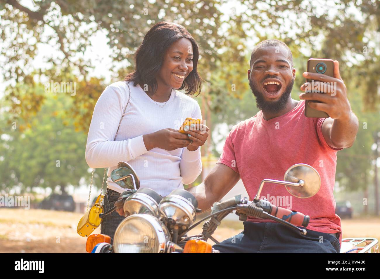 l'uomo e la donna africani guardano il telefono eccitatamente Foto Stock