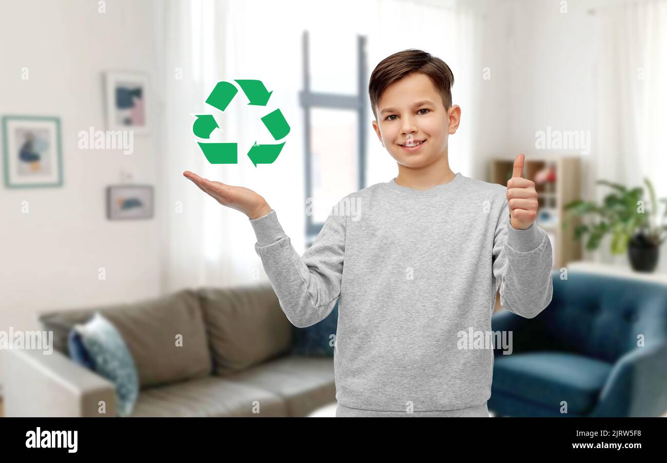 ragazzo con il cartello verde di riciclaggio che mostra i pollici in su Foto Stock