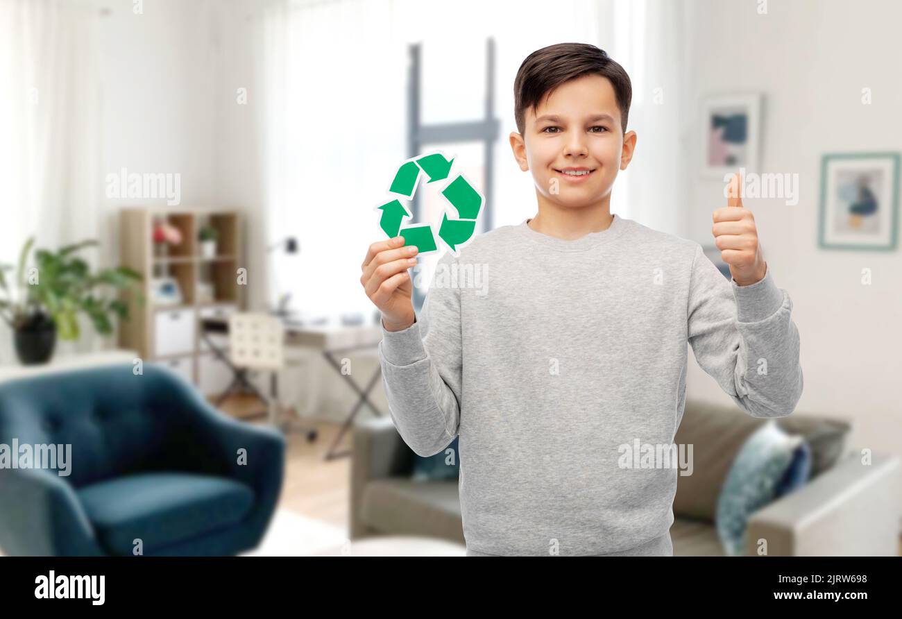 ragazzo con il cartello verde di riciclaggio che mostra i pollici in su Foto Stock