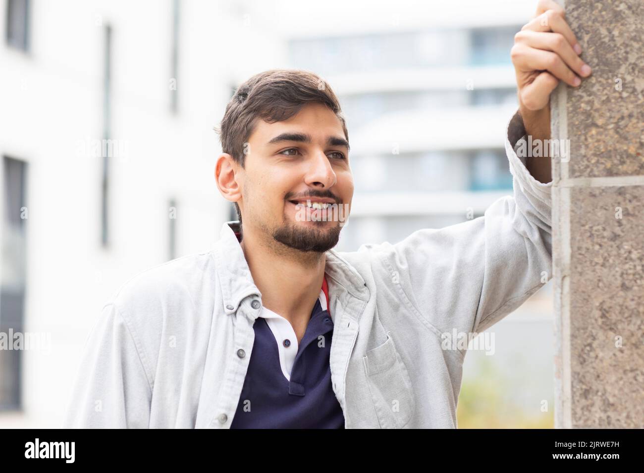 giovane uomo appoggiato a un muro di un edificio Foto Stock