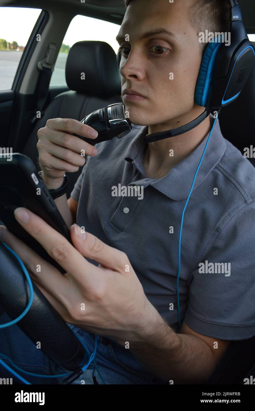 Guida distratta, rasatura e utilizzo del telefono durante la guida Foto Stock