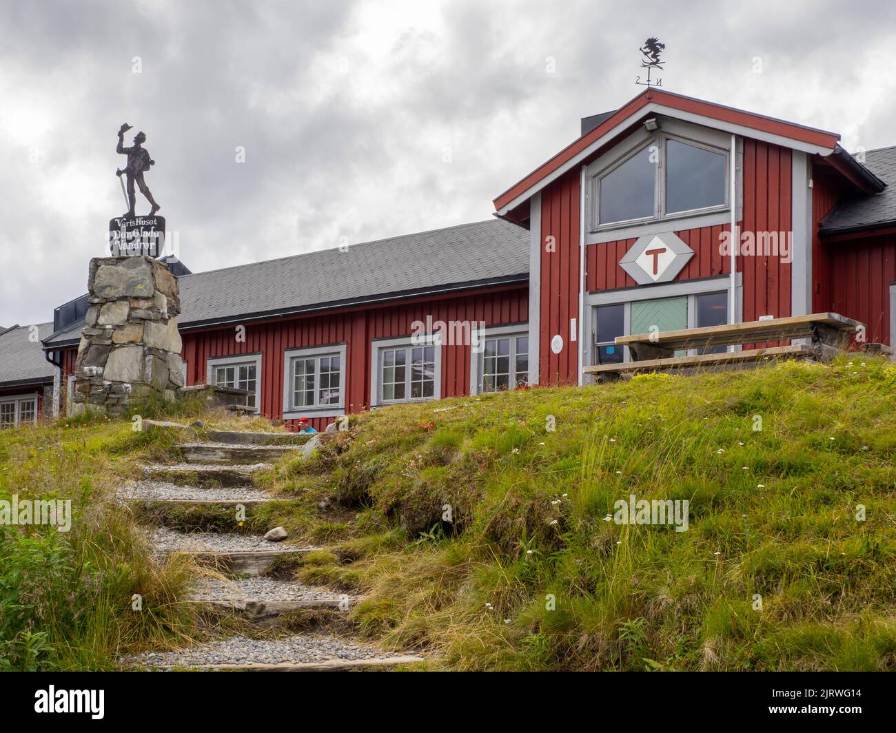 Den Glade Vandret l'Happy Wanderer al di fuori della confortevole capanna Fondsbu DNT a Eidsbugarden, alla testa del lago Bygdin, in Norvegia Jotunheimen Foto Stock