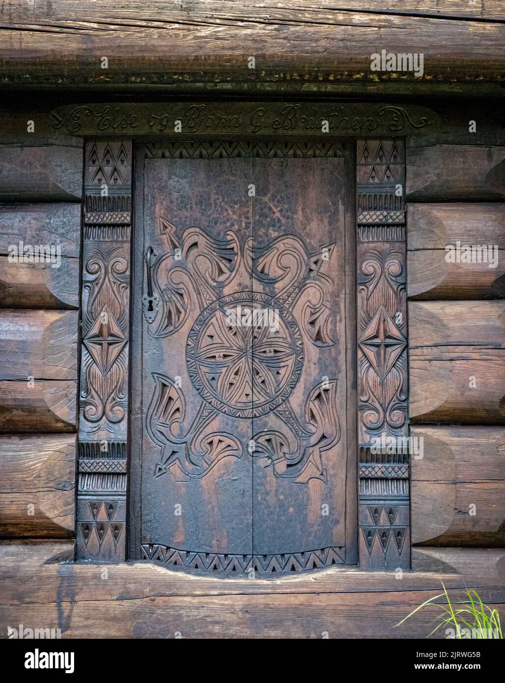 Porte intagliate su cabine in legno nel villaggio storico di Eidsbugarden, alla testa del lago Bygdin Norvegia Foto Stock