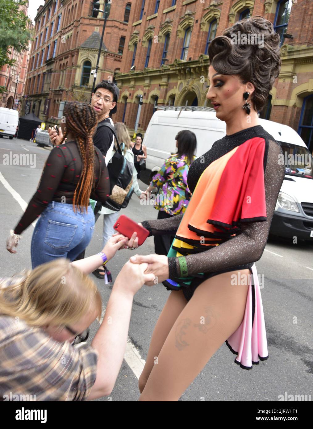 Manchester, Regno Unito. 26th agosto, 2022. Una persona in costume aiuta qualcuno ad alzarsi. LGBTQ+ Pride, Manchester, Regno Unito, inizia e continua durante il fine settimana delle festività dal 26th al 29th agosto nel villaggio gay di Manchester. Gli organizzatori dicono: 'Manchester Pride è una delle principali associazioni di beneficenza del Regno Unito LGBTQ+. La nostra visione è un mondo in cui le persone LGBTQ+ sono libere di vivere e amare senza pregiudizi. Facciamo parte di un movimento Pride globale che celebra l'uguaglianza LGBTQ+ e la sfida della discriminazione." Credit: Terry Waller/Alamy Live News Foto Stock