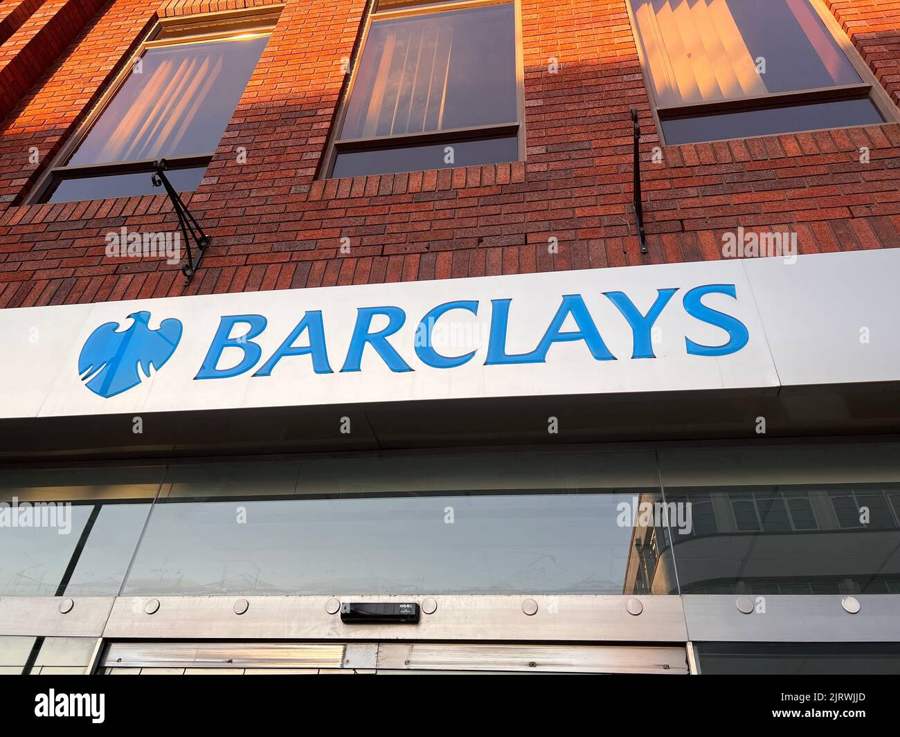 Un'inquadratura a basso angolo del logo blu di Barclays di fronte alla Bank in Rugby Foto Stock