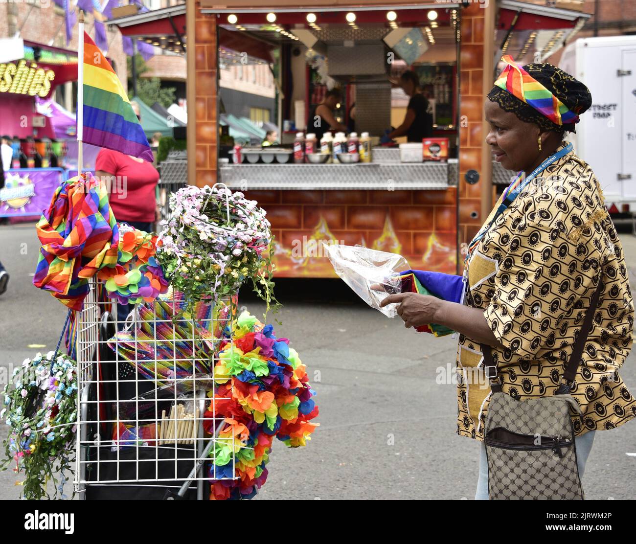 Manchester, Regno Unito. 26th agosto, 2022. Un venditore di strada vende arcobaleno paraphernalia. LGBTQ+ Pride, Manchester, Regno Unito, inizia e continua durante il fine settimana delle festività dal 26th al 29th agosto nel villaggio gay di Manchester. Gli organizzatori dicono: 'Manchester Pride è una delle principali associazioni di beneficenza del Regno Unito LGBTQ+. La nostra visione è un mondo in cui le persone LGBTQ+ sono libere di vivere e amare senza pregiudizi. Facciamo parte di un movimento Pride globale che celebra l'uguaglianza LGBTQ+ e la sfida della discriminazione." Credit: Terry Waller/Alamy Live News Foto Stock