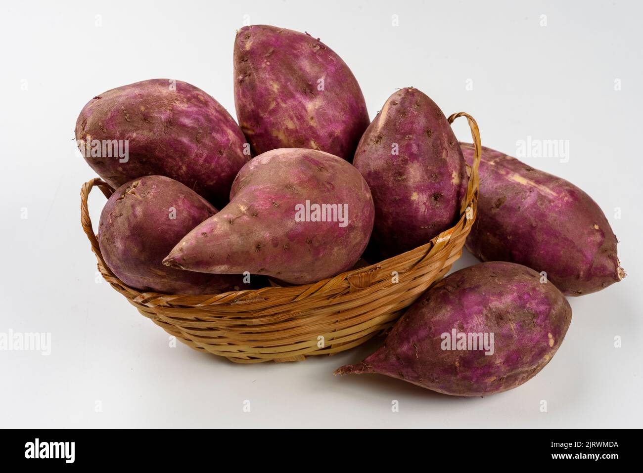 Patate dolci in un cestino isolato su fondo bianco. Foto Stock