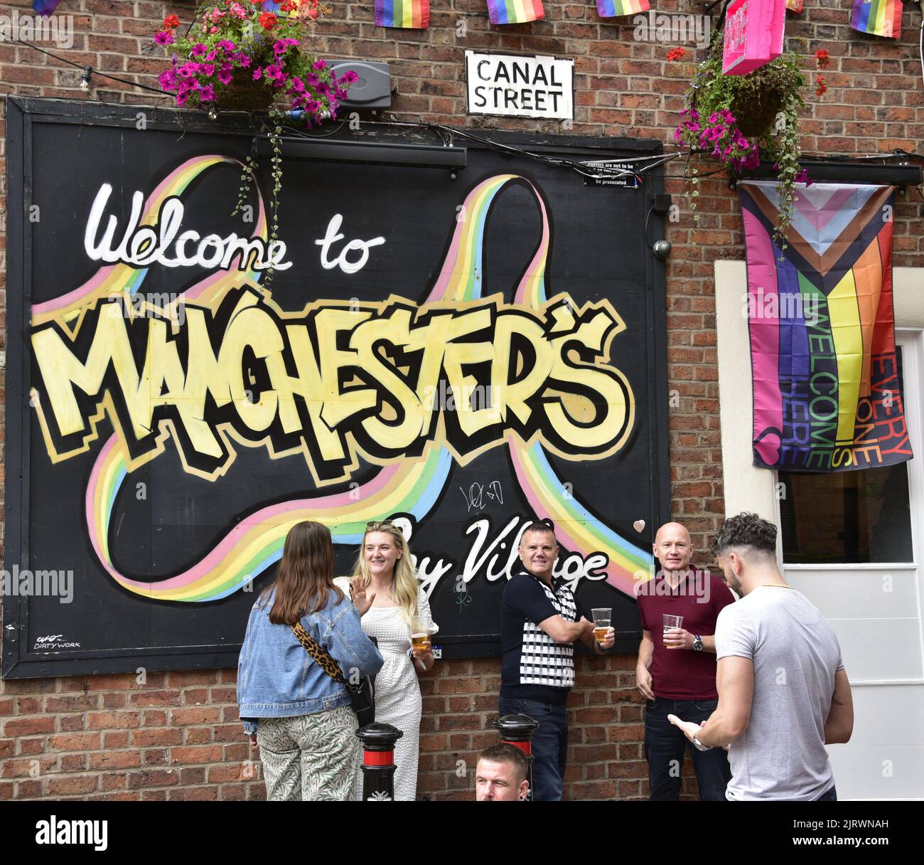 Manchester, Regno Unito. 26th agosto, 2022. Cartello "Welcome to Manchester's Gay Village". LGBTQ+ Pride, Manchester, Regno Unito, inizia e continua durante il fine settimana delle festività dal 26th al 29th agosto nel villaggio gay di Manchester. Gli organizzatori dicono: 'Manchester Pride è una delle principali associazioni di beneficenza del Regno Unito LGBTQ+. La nostra visione è un mondo in cui le persone LGBTQ+ sono libere di vivere e amare senza pregiudizi. Facciamo parte di un movimento Pride globale che celebra l'uguaglianza LGBTQ+ e la sfida della discriminazione." Credit: Terry Waller/Alamy Live News Foto Stock