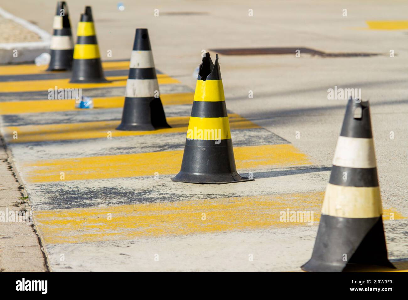 Cono segnaletico di colore nero con strisce gialle a Rio de Janeiro. Foto Stock