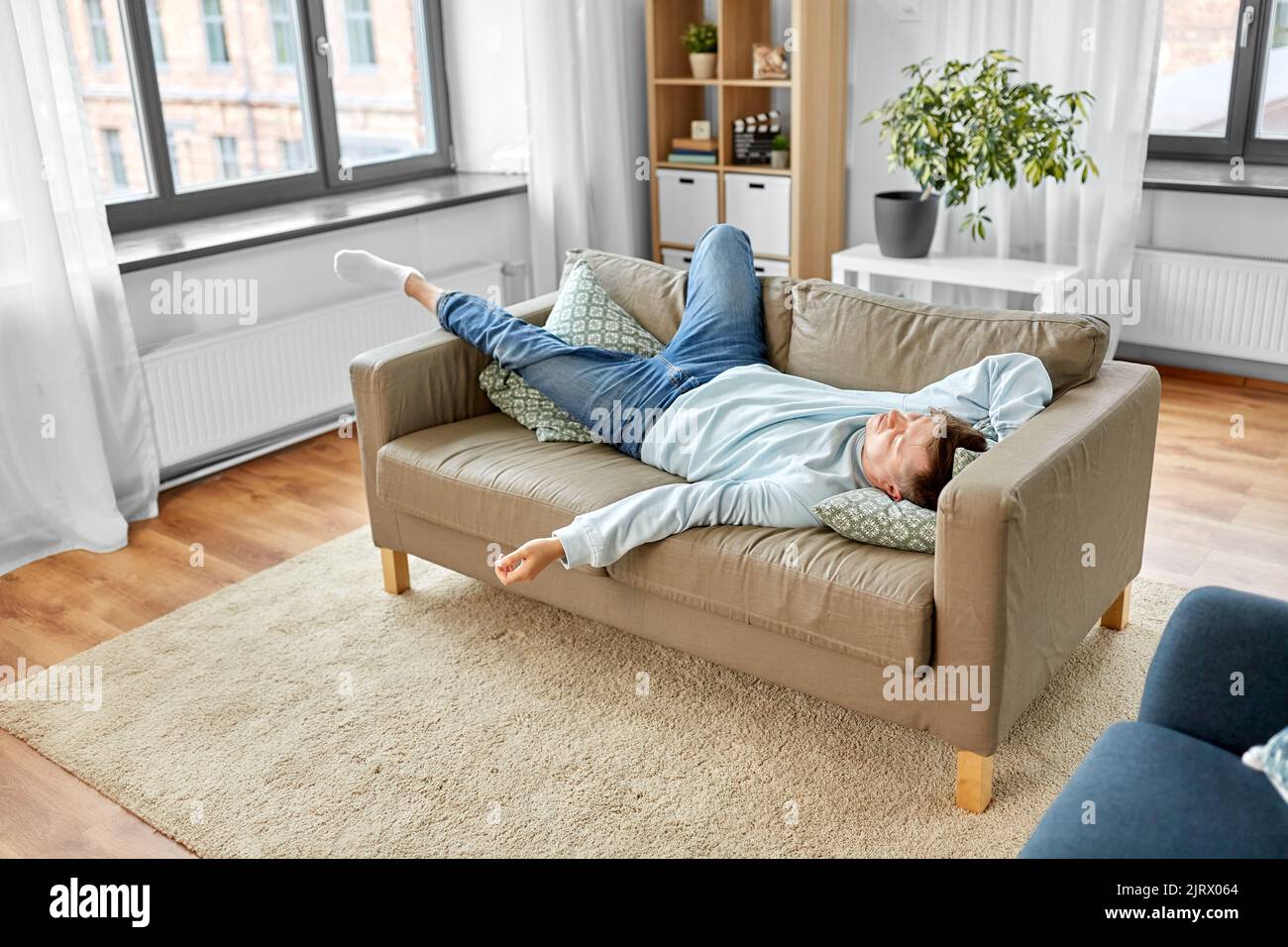 un giovane che dorme sul divano a casa Foto Stock