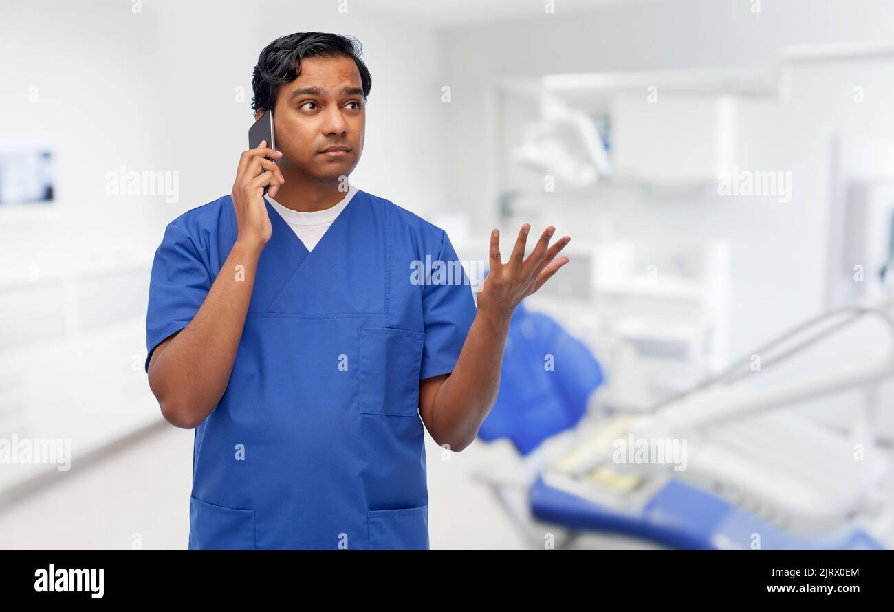 medico indiano che chiama al telefono presso l'ufficio dentistico Foto Stock