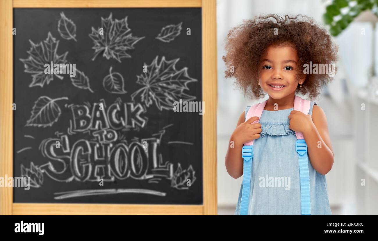 felice piccola ragazza afroamericana con zaino Foto Stock