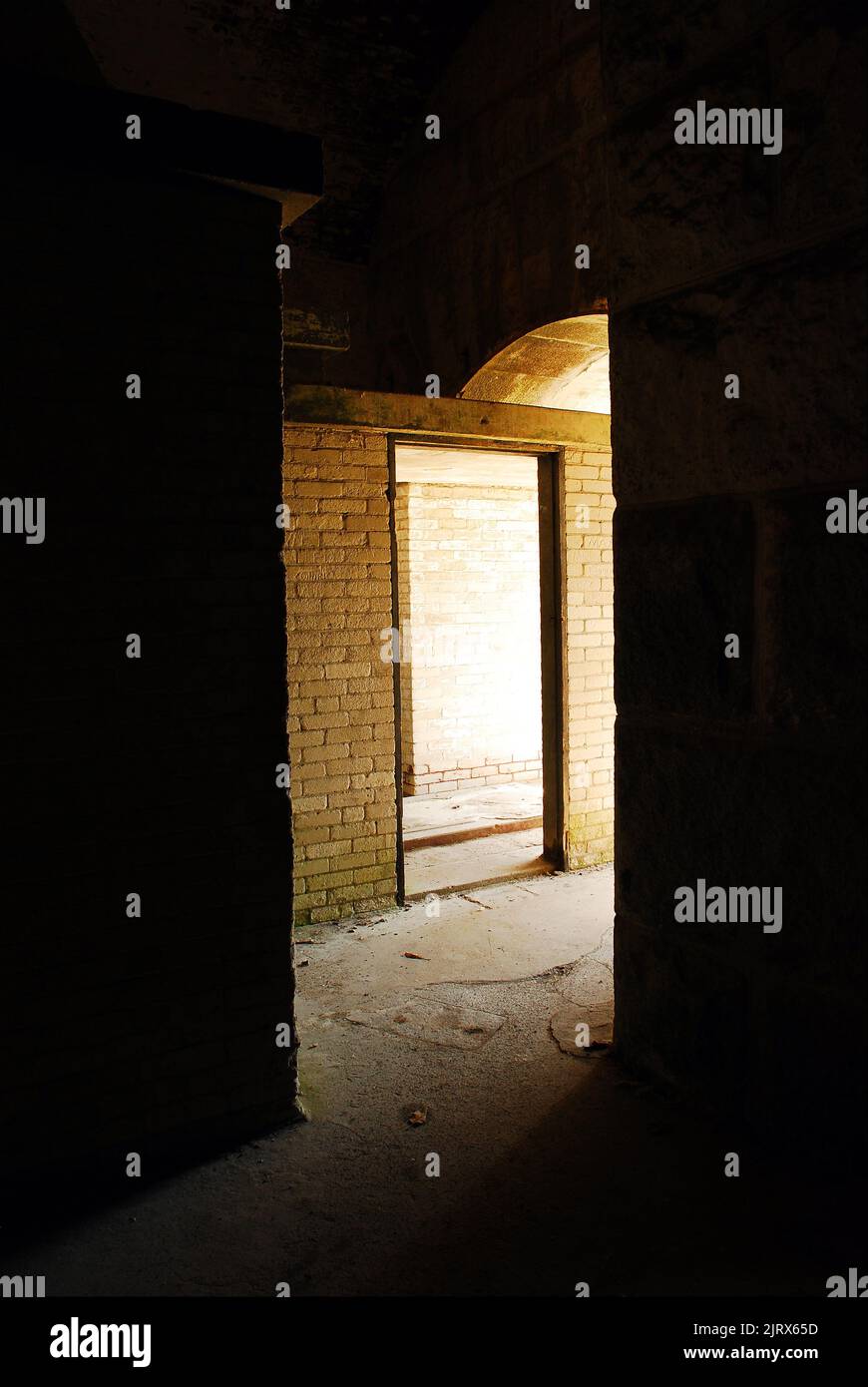 Un'apertura in un antico forte militare conferisce un'aria di mistero e intrigo mentre la luce naturale entra nell'interno oscurato Foto Stock